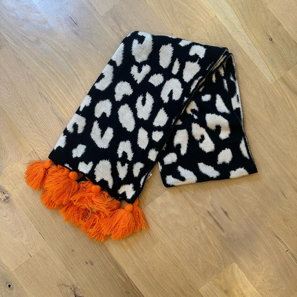 Trendy Boutique Black and White Leopard Print Scarf with Orange Tassels